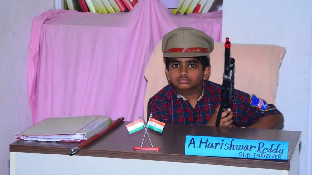 Young Hariswara in a police cap at a desk