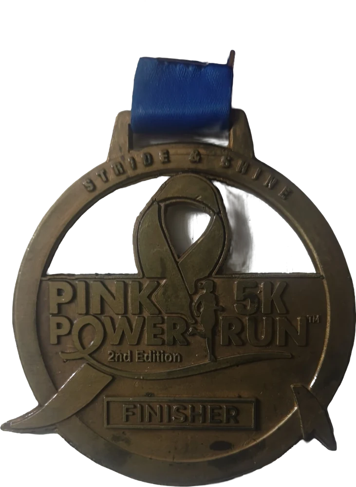Bronze Pink Power 5K Run finisher medal with a ribbon emblem, on a blue ribbon